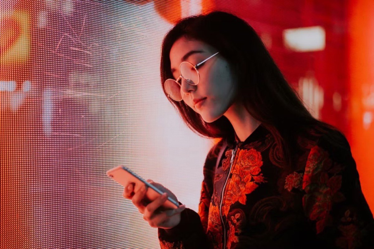 Woman lit by a red LED video wall, shot with a wide-aperture lens