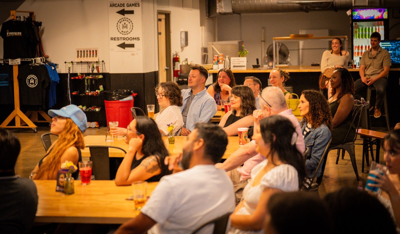 Full tables of people laughing during a live comedy show